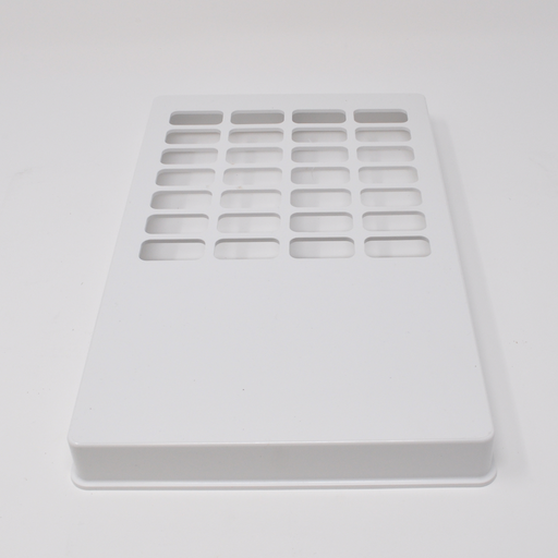 A white rectangular plate with numerous rectangular cutouts sits on a white surface.