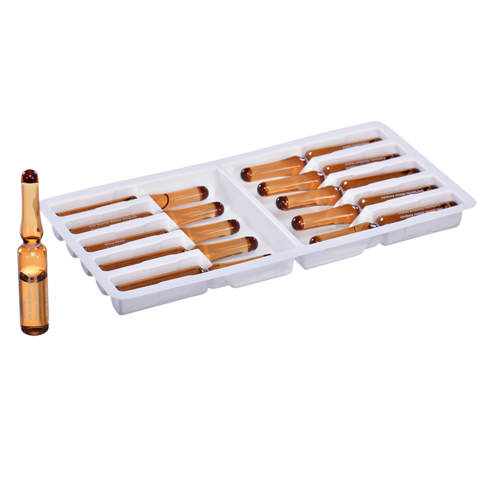Amber ampoules rest in a white plastic tray. One ampoule is separated, suggesting removal. The ampoules appear to be a pharmaceutical product.