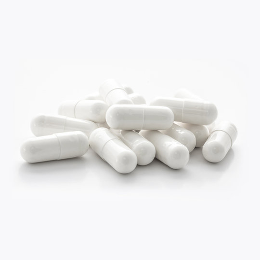 White capsules are piled loosely on a plain white surface.
