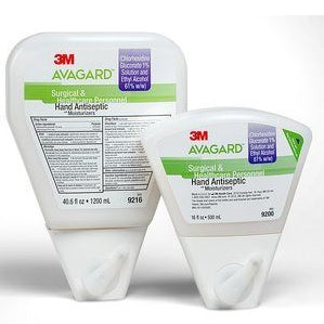 Two wall-mounted hand antiseptic dispensers sit side-by-side. One is larger than the other. Both are labeled "3M AVAGARD Surgical & Healthcare Personnel Hand Antiseptic" and list Chlorhexidine Gluconate 0.5% solution and Ethyl Alcohol 61% w/w. Product numbers 9216 and 9200 are visible.