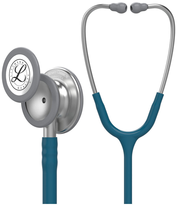 A Littmann Classic III stethoscope, teal-colored with grey accents, rests against a white background. "Littmann Classic III Made in U.S.A." is inscribed on the chest piece.