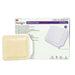 A beige silicone foam dressing rests on a purple and white box. The box labels it as 3M Tegaderm Silicone Foam, listing various language translations. The context is a sterile medical product package.