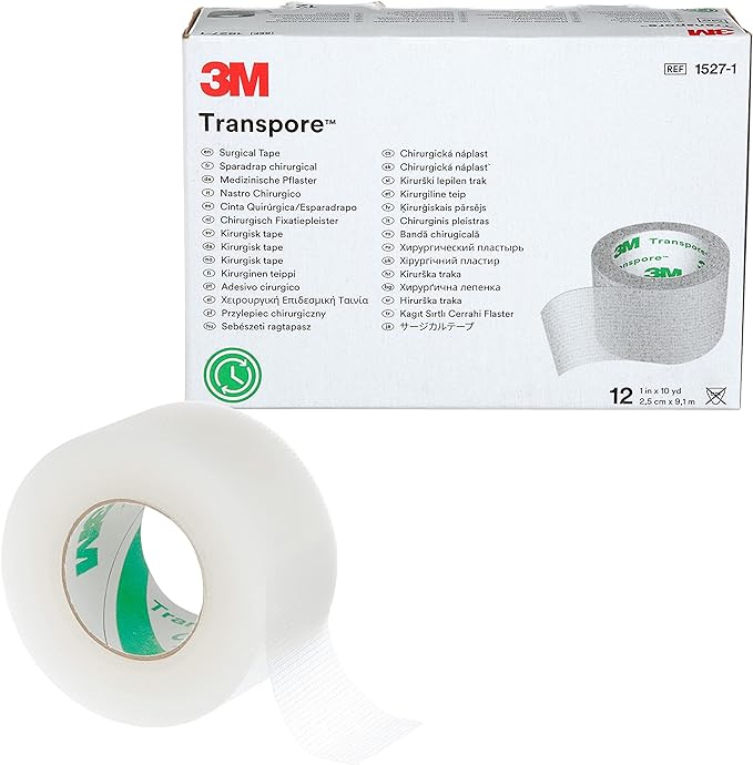 A roll of 3M Transpore surgical tape rests beside its packaging; the box lists the product name and its translation in numerous languages.