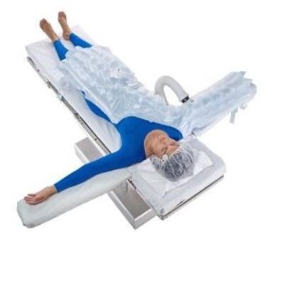 A person lies on a surgical table, covered in a sterile drape, arms extended on padded armrests. The context is a medical operating room.