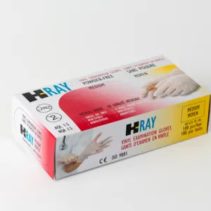 A box of H-Ray medium vinyl examination gloves sits on a plain background. The box displays images of gloved hands and contains multilingual product information including "SANS POUDRE" (powder-free), "MEDIUM", "CE ISO 9001", and "2".