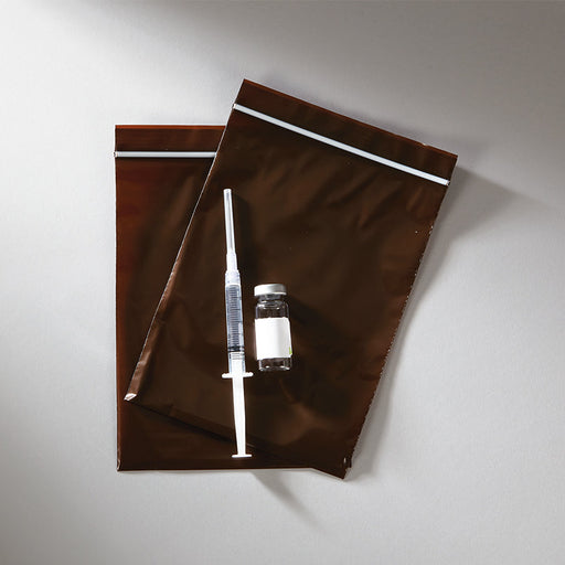 Two brown pouches lie atop a surface; a syringe and vial rest on top.