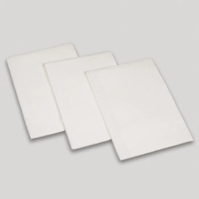 Three rectangular white pads are stacked, overlapping slightly, on a light gray surface.