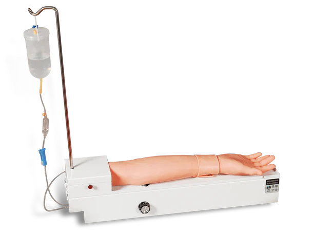 An artificial arm is receiving an intravenous drip from a fluid bag via tubing, on a training device.