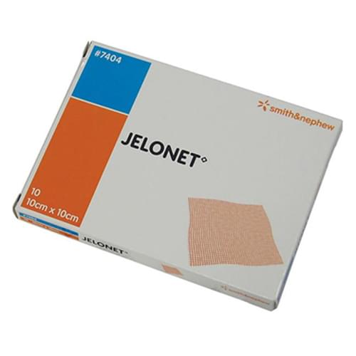 A box containing ten 10cm x 10cm JELONET® bandages sits on a surface. #7404. smith&nephew.