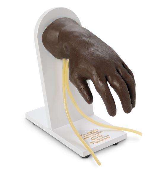 A dark brown prosthetic hand rests on a white stand, its fingers slightly splayed. Yellow cords, seemingly veins, extend from the wrist and drape down the stand.