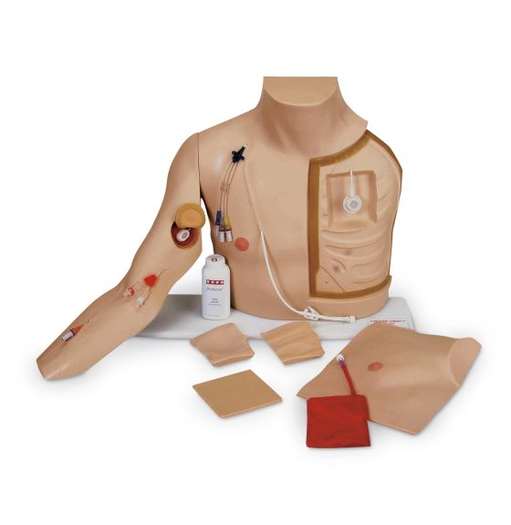 A medical training mannequin simulates various medical procedures with IV lines and an implantable port, accompanied by training accessories like fake skin patches, on a white surface. A bottle that says “tru-prep” is found among the patches.