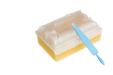 A rectangular sponge brush, featuring a dense, white bristle top, rests on a surface. A light blue cleaning tool lies atop the brush.