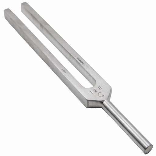 A metal tuning fork sits upright against a plain white background. It appears to be unused.