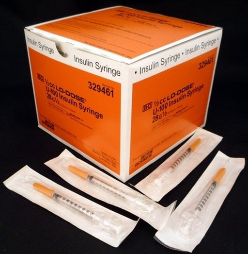A box of BD 1/2cc LO-DOSE U-100 insulin syringes (28G ½) rests on a surface, with several individually packaged syringes arranged nearby. The box is orange and displays product information and lot number 329461.