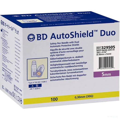 A box of BD AutoShield Duo safety pen needles with dual automatic protective shields sits on a surface. The box contains 100 needles, 0.30mm (30G) x 5mm in size. REF 329505, NDC# 08290-3295-05.