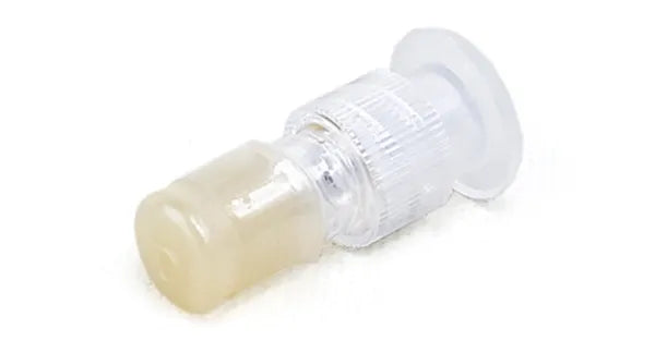 A plastic connector sits on a white surface. It is translucent, with one opaque, off-white end.