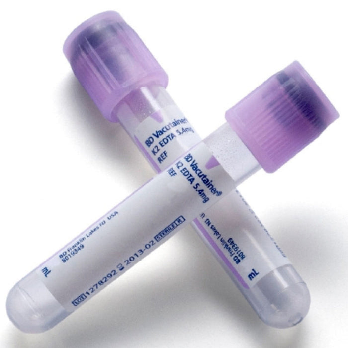 Two BD Vacutainer tubes, containing K2 EDTA 5.4mg, lay crossed on a white background. The tubes are transparent with lavender stoppers and contain labels with identifying information including lot numbers and expiration dates.