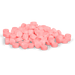 Many pink pills are piled haphazardly against a black background.