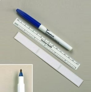 A blue marker pen and a small ruler lie atop a white adhesive bandage; all rest on a plain, light gray surface. The marker is labeled "Cardinal Health."