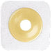 A beige, ring-shaped adhesive disk sits centered on a larger, square, off-white fabric patch.