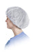 A bouffant cap sits atop a person's head, covering their hair; the person is shown in profile against a white background, wearing a light blue scrub top.