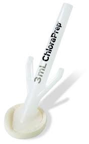 A white plastic applicator, containing a liquid, rests on a flat surface. The applicator has a three-pronged base and the label reads "3mL ChloraPrep".