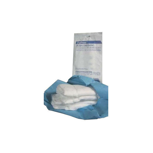 A stack of sterile burn dressings sits within a light-blue wrapper. The outer packaging labels it as “BURN DRESSING,” “PANSEMENT POUR BRULURES,” and “APOSITO DE LA QUEMADURA.”