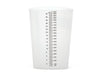 A cylindrical plastic measuring cup sits on a plain white background. It is transparent and features a vertical scale printed on its side for measuring volume.