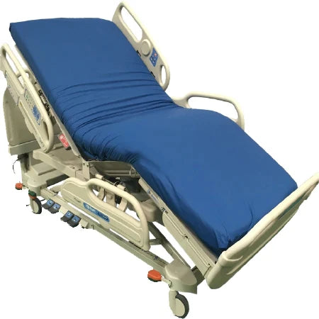 A hospital bed rests on wheels, featuring a blue mattress. The bed is in an elevated position.