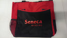 A red and black tote bag rests on a white surface. The bag features the words "Seneca NURSING" printed on its front.