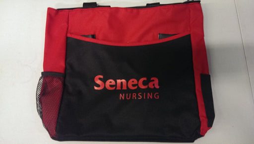 A red and black tote bag rests on a surface. The bag features the words "Seneca NURSING" in red lettering.