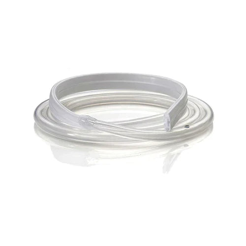 A clear plastic tubing, coiled, lies on a white surface. A rigid white section is integrated into the tubing.