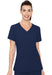 A woman in a navy blue v-neck scrub top stands against a white background. She is smiling.