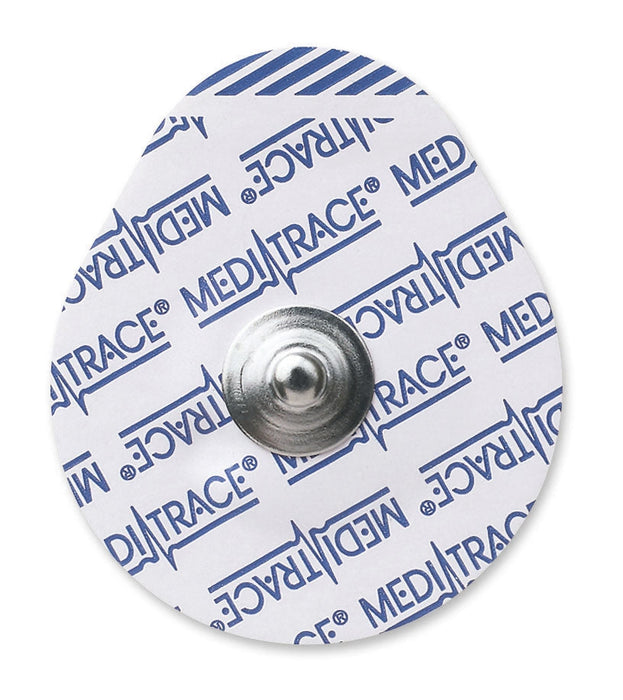 A small, round adhesive electrode rests on a plain white background. The electrode has a metallic center and printed text that is illegible.