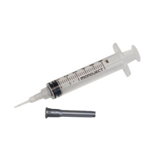 A clear plastic syringe rests on a white background; a separate black needle lies beside it.