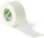 A roll of Curad medical tape unrolls on a white background. The tape is off-white, and the inner roll displays the Curad logo repeatedly.
