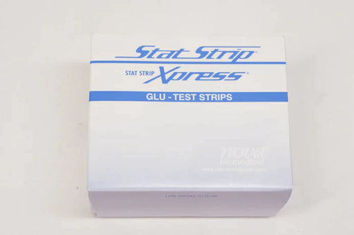 A box of Stat Strip Xpress Glu-Test Strips sits on a white surface. The box is predominantly white with blue text and logo. "STAT STRIP Xpress" and "GLU - TEST STRIPS" are prominently displayed. A smaller "NOVA Biomedical" logo is also present.