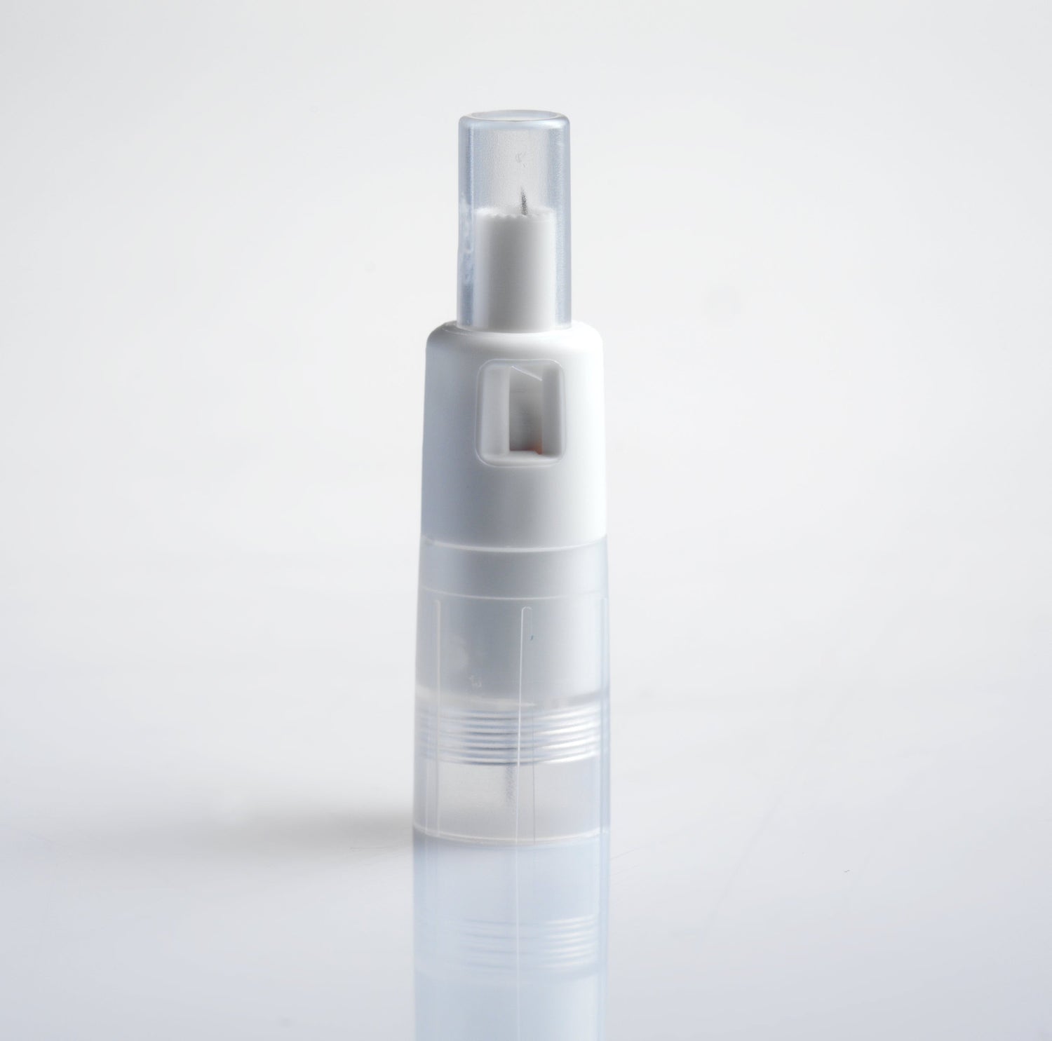 A white pen-like object stands upright on a white surface. The object has a clear top section and a slightly translucent bottom section.