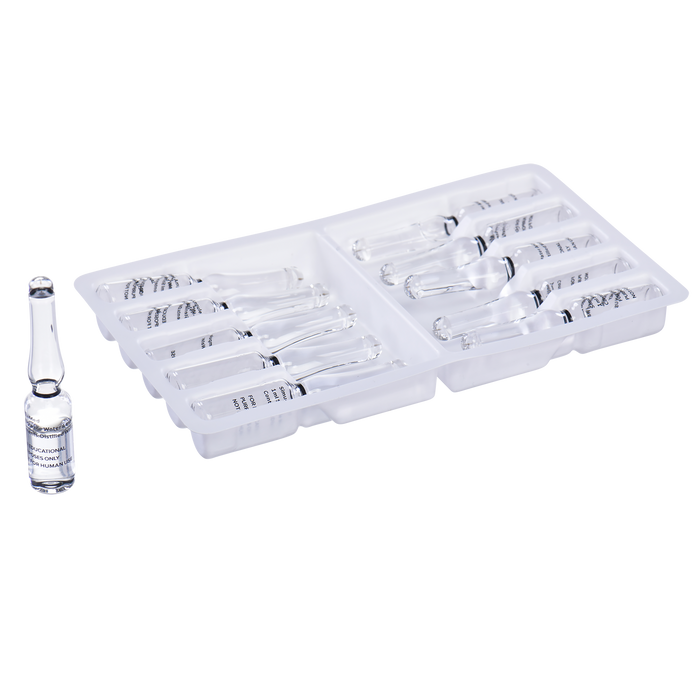 Glass ampoules containing liquid rest in a plastic tray; one ampoule sits separately.