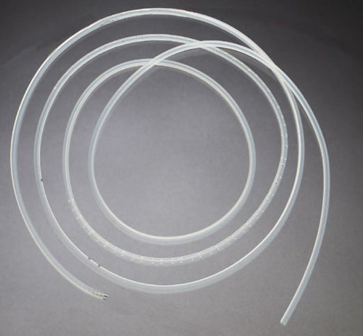 A transparent tube, coiled, lies on a gray surface. The tube has small perforations along its length.