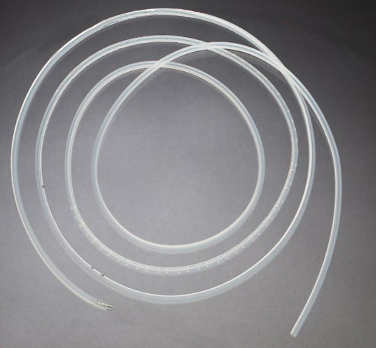 A transparent tube, coiled, lies on a gray surface. The tube has small perforations along its length.