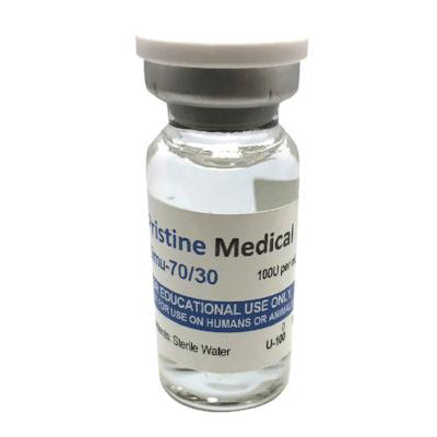 A small vial containing a clear liquid sits on a surface. The label reads "Pristine Medical," "Mu-70/30," "100U per ml," "EDUCATIONAL USE ONLY," "FOR USE ON HUMANS OR ANIMALS," "Sterile Water," and "U-100".
