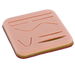 A pale pink, layered practice skin displays various incised lines and curves for suture training.