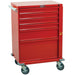 A red, wheeled tool chest sits on a light-colored surface. It features five drawers and a large bottom compartment. The chest has a handle on the side and what appears to be a small manufacturer's label on top.