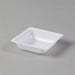 A small, square, white plastic dish sits on a gray surface.