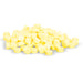 Pale yellow pills are piled on a white background.