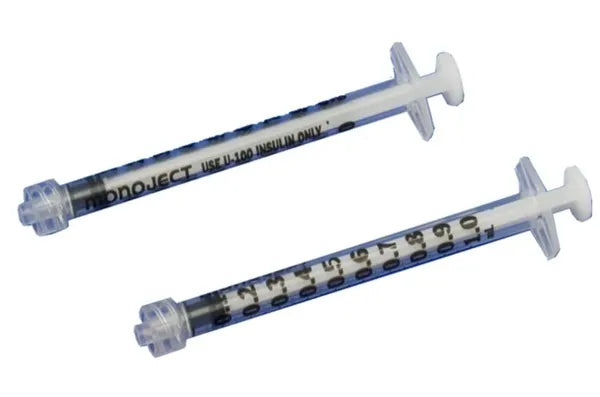 Two Monoject syringes lie on a surface; they are calibrated for U-100 insulin only.