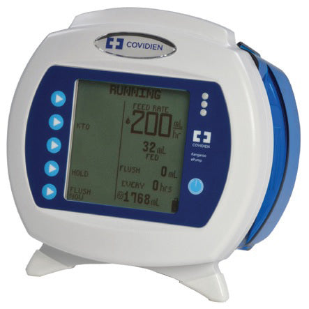 A portable medical infusion pump displays data on an LCD screen; it sits on a flat surface.