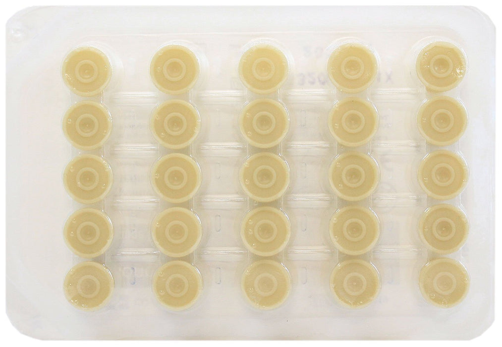 Thirty small, light-beige, circular objects are arranged in a gridded, clear plastic tray.