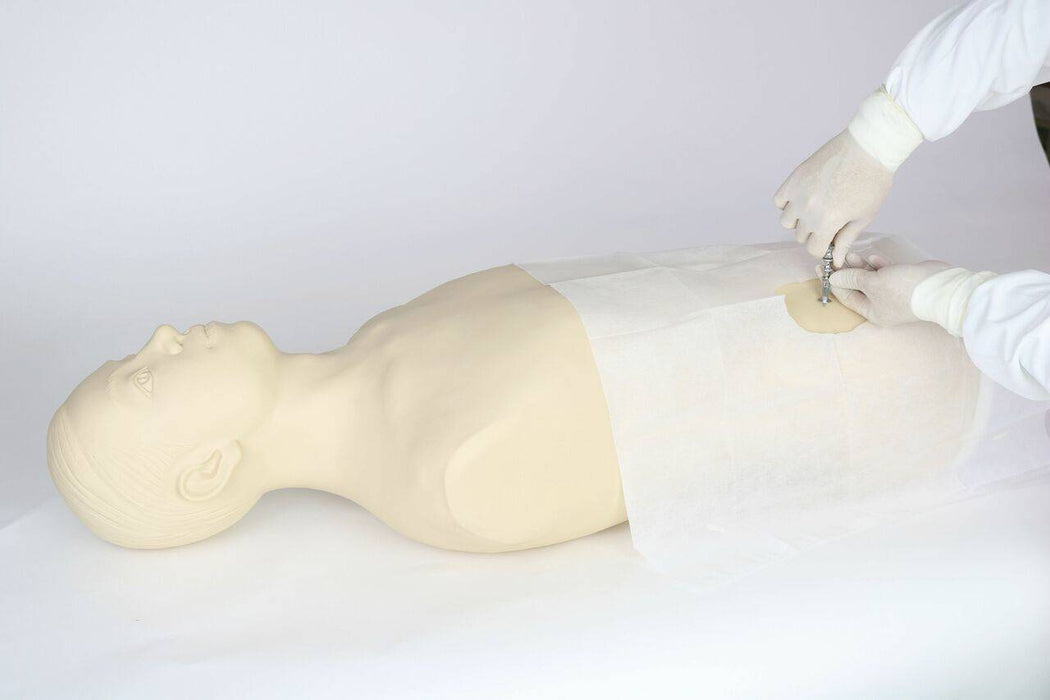 A medical mannequin lies supine; gloved hands insert a device into its torso; a white drape covers its midsection.
